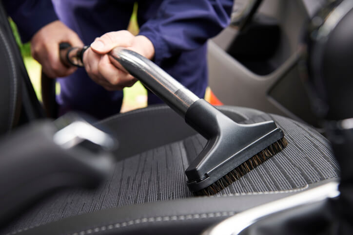 Auto detailing professional cleaning a vehicle’s interior in your auto detailing career