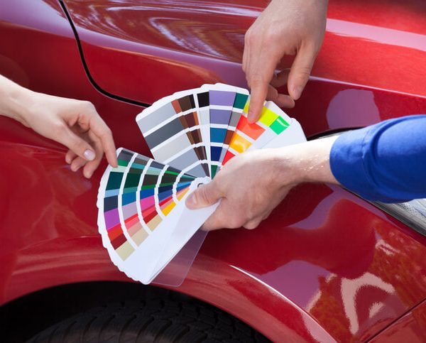 Student in auto body training holding color samples