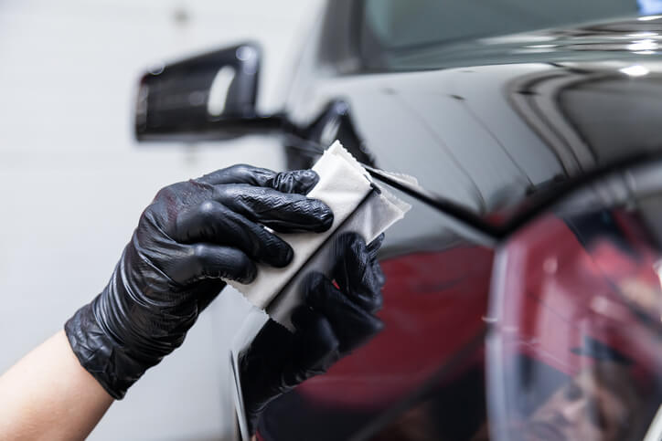 Student in auto body training polishing a car