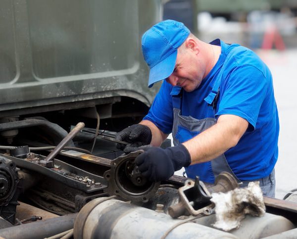 Diesel mechanic working on a truck engine after diesel mechanic training