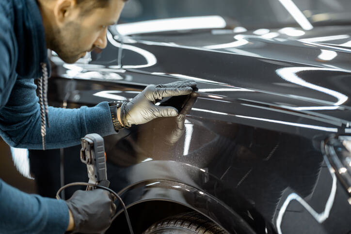 Student in auto body training smiling in the garage