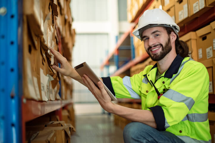 A dispatch training graduate working on a tablet in a warehouse.