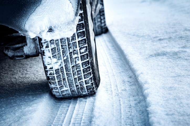 Winter tires on snow terrain as recommended by auto mechanic school for vehicle winter preparations.