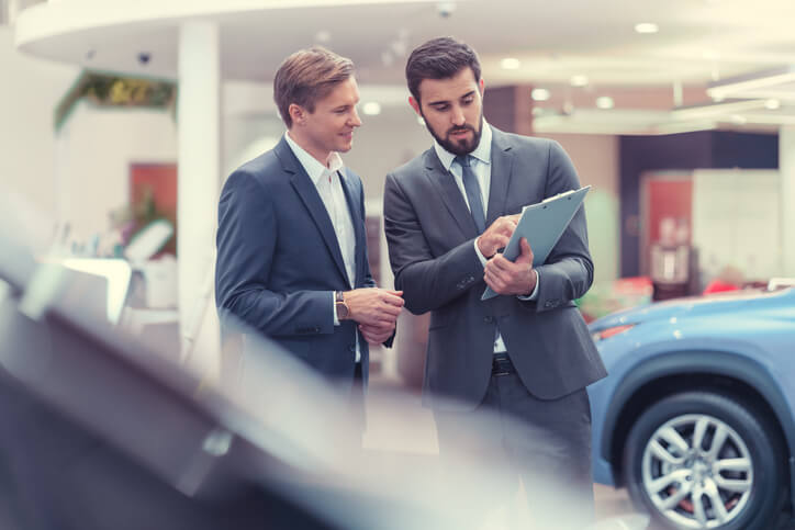 An automotive training grad managing a car dealership