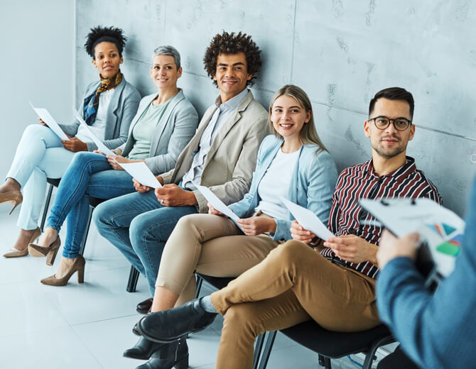 An automotive training grads in chairs awaiting their turn at a job interview