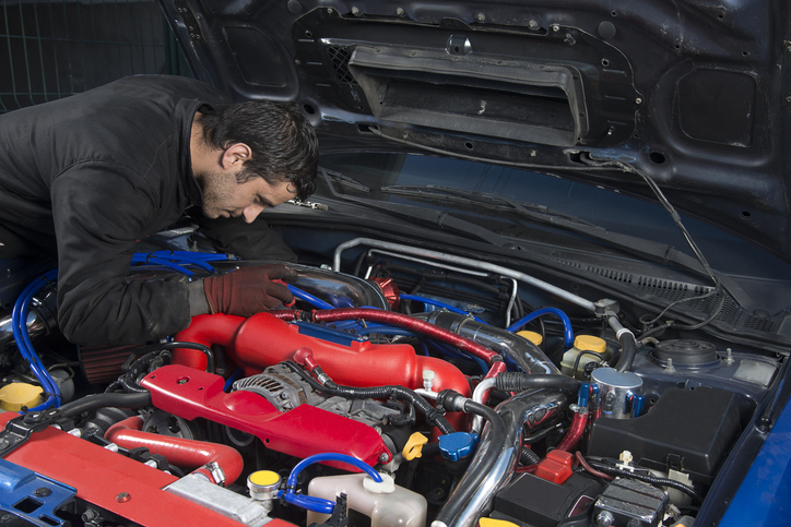 Focused diesel mechanic working on a race car’s engine