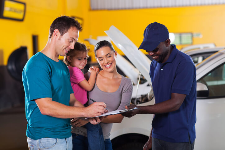 A friendly auto mechanic interacting with customers