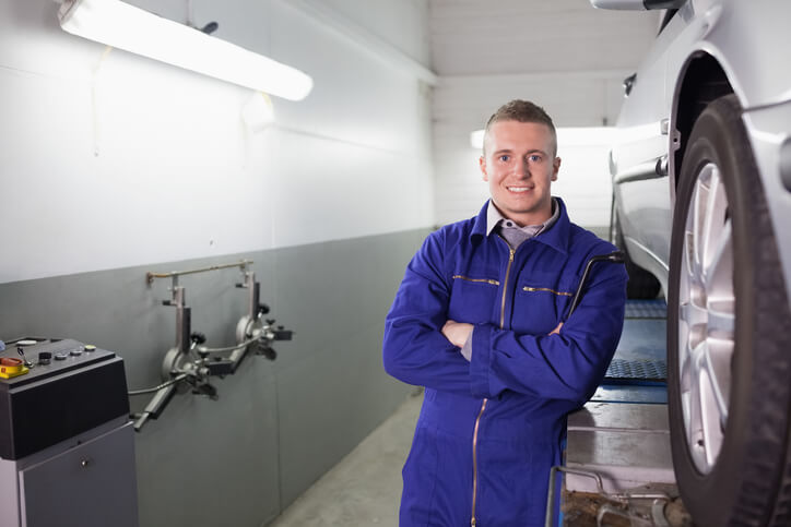 A confident auto mechanic at a garage