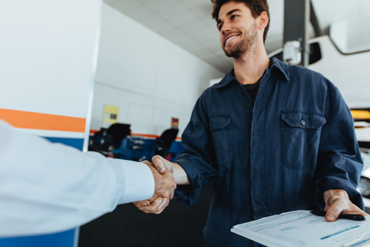 An auto mechanic training grad shaking hands with a new employer