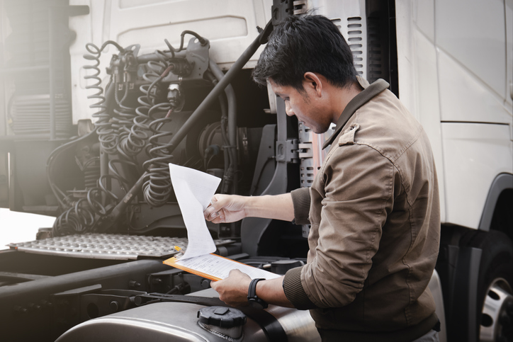 A diesel mechanic training graduate conducting a truck inspection