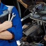 A male auto mechanic at a garage after completing his auto mechanic training