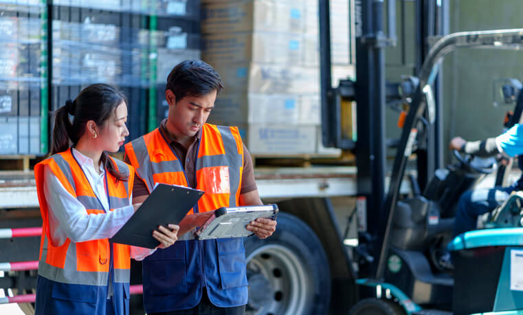 A dispatch training grad discussing work with a driver outside of a truck