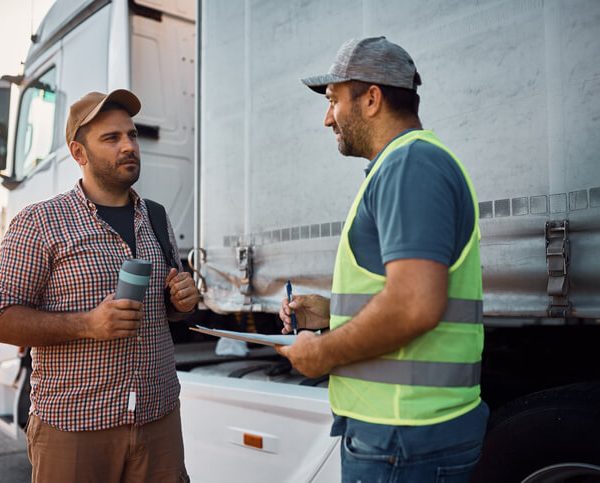 A dispatch training grad talking to a colleague in a warehouse