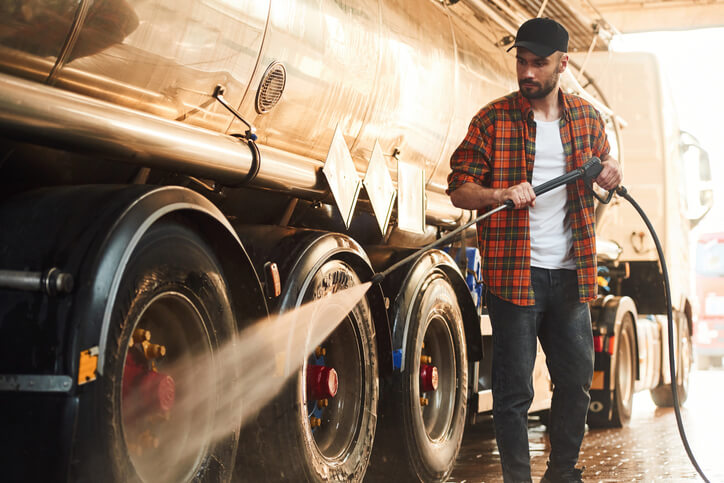 A male auto detailing professional cleaning a truck's tires