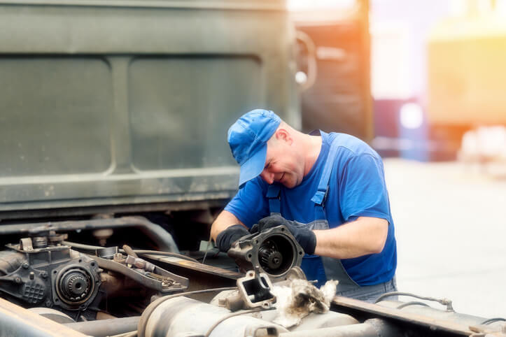 A diesel mechanic training grad servicing a truck