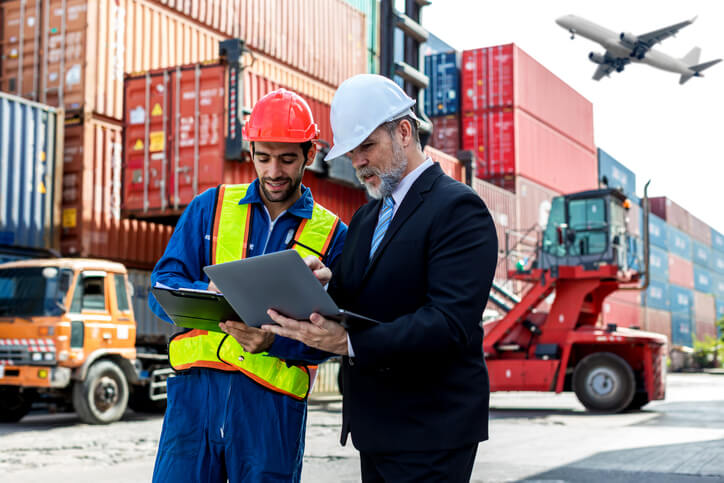 A pair of dispatch professionals tracking the journey of a shipment after completing their dispatch training