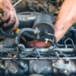 A male mechanic working on a diesel engine after completing his diesel mechanic training