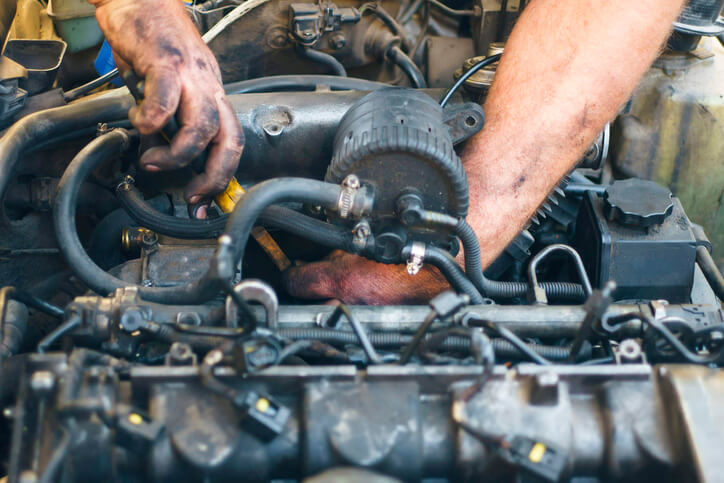 A male mechanic working on a diesel engine after completing his diesel mechanic training