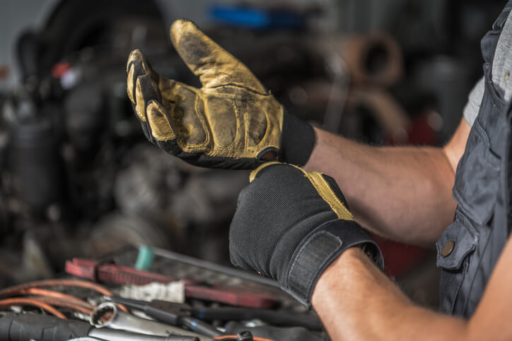 A male mechanic repairing a heavy-duty diesel engine after completing his diesel mechanic training