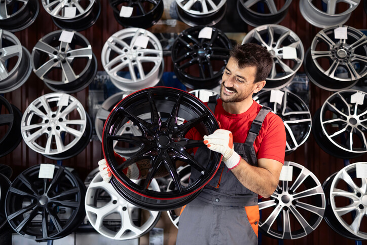 A graduate of auto detailing training selects custom rims for a vehicle project