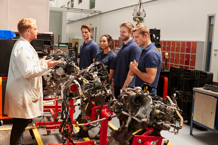 A group of students receiving hands-on auto parts training at CATI