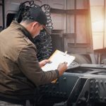 A diesel mechanic training grad inspecting a truck