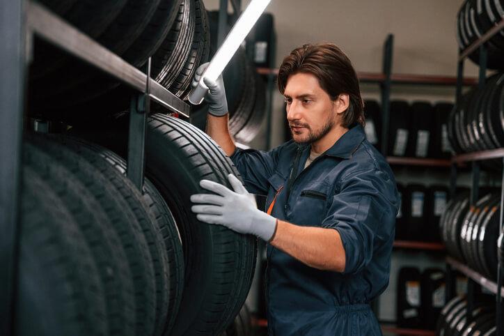 An auto parts training grad managing inventory in a tire warehouse